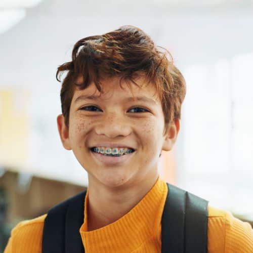 Young boy with braces smiling with backpack | Kania and Khan Orthodontics in Asheboro, NC