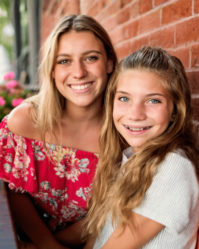 Two women smiling together outdoors casual photo | Kania and Khan Orthodontics in Asheboro, NC