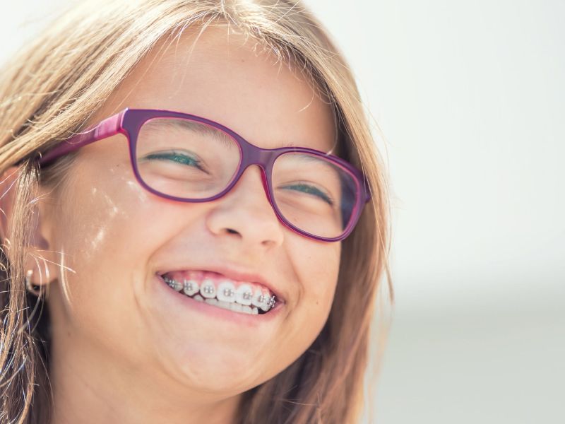 Girl with purple glasses and braces smiling | Kania and Khan Orthodontics in Asheboro, NC
