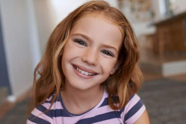 Young girl smiling brightly after orthodontic visit in Asheboro, NC